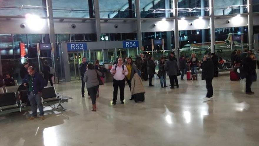 Algunos de los afectados esperan en la terminal de Valencia, tras bajar del primer avión.
