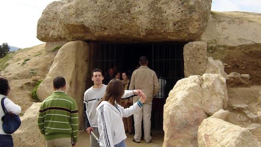 Un grupo de visitantes se acerca a la gruta del túmulo.