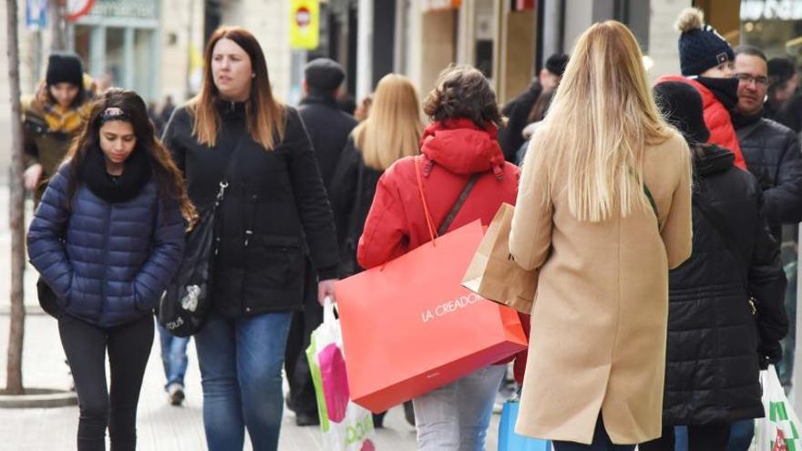 Vianants amb bosses a les mans, al carrer d&#039;Àngel Guimerà