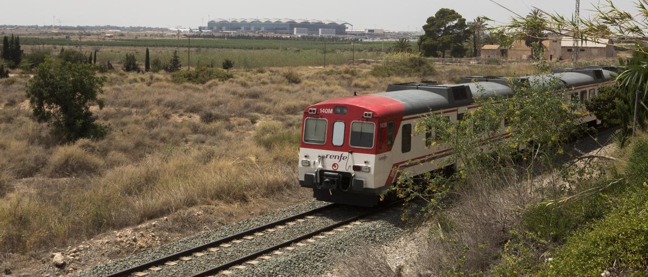 Un  tren  de la línea de cercanías Murcia-Alicante camino de San Gabriel. Al fondo, el aeropuerto