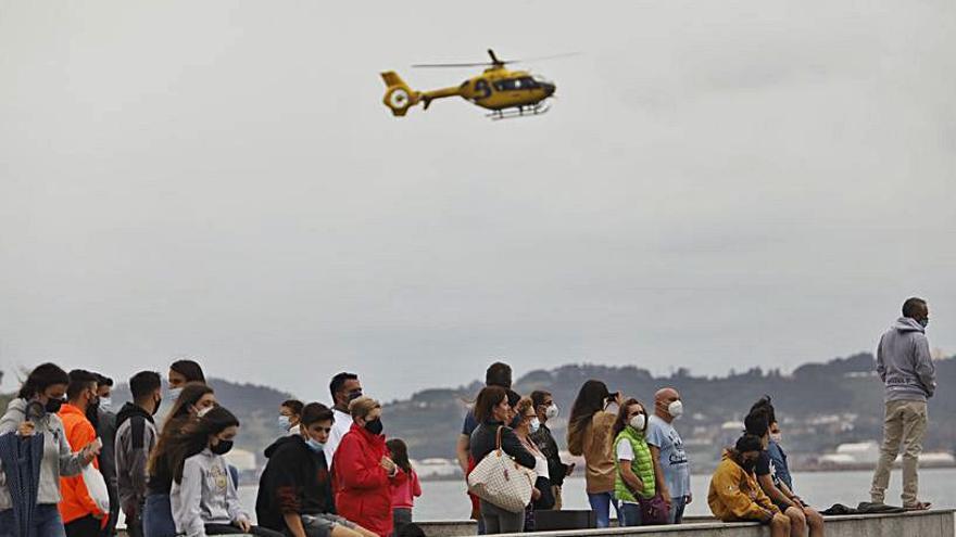  Curiosos en la zona de El Rinconín viendo el rescate, con el helicóptero de los bomberos sobre sus cabezas. | Marcos León