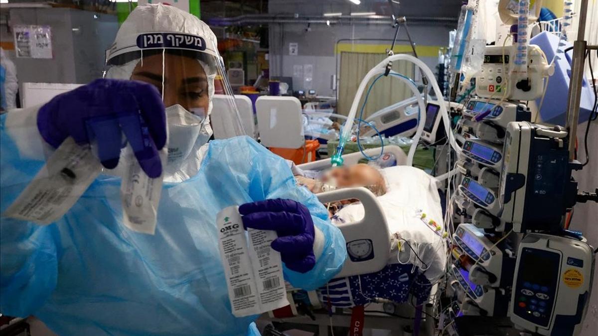 A medic cares for a COVID-19 patient at the Sheba Medical Center s isolation ward  in Ramat Gan near the Israeli coastal city of Tel Aviv  on January 18  2021  (Photo by JACK GUEZ   AFP)