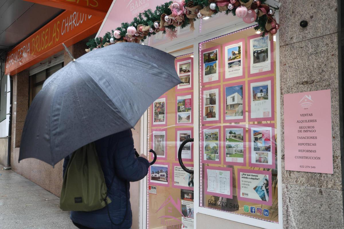 Una persona observa el escaparate de una inmobiliaria en Vigo.