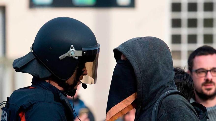 Un agente antidisturbios de los Mossos d&#039;Esquadra y un manifestante, durante las protestas del jueves en Gerona.