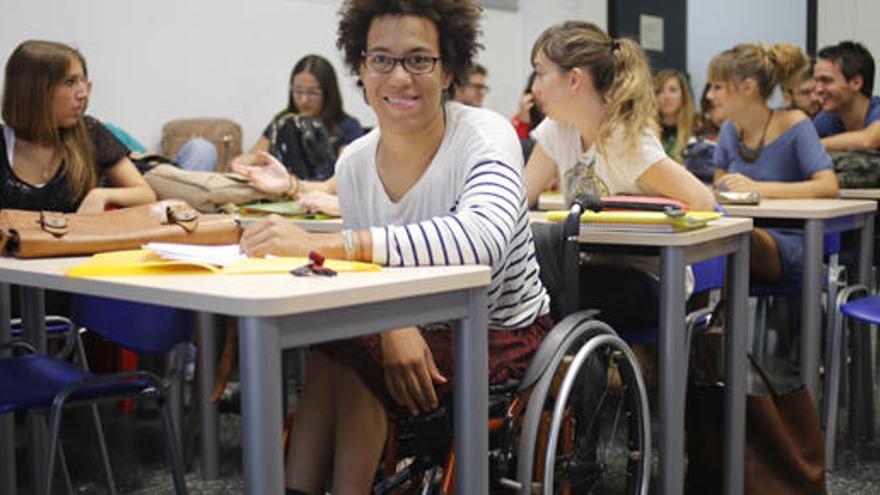 Una alumna en silla de ruedas en una clase universitaria.