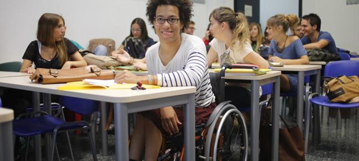 Una alumna en silla de ruedas en una clase universitaria.