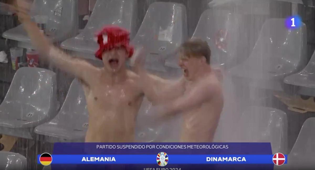 ¡Ya es la imagen viral de la Euro! Dos fans y su &quot;ducha&quot; en el parón del Alemania - Dinamarca por la tormenta