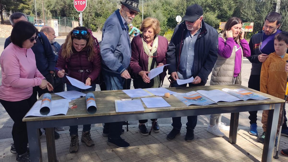 Vecinos firman a favor de la apertura del camino en la concentración del 17 de marzo.
