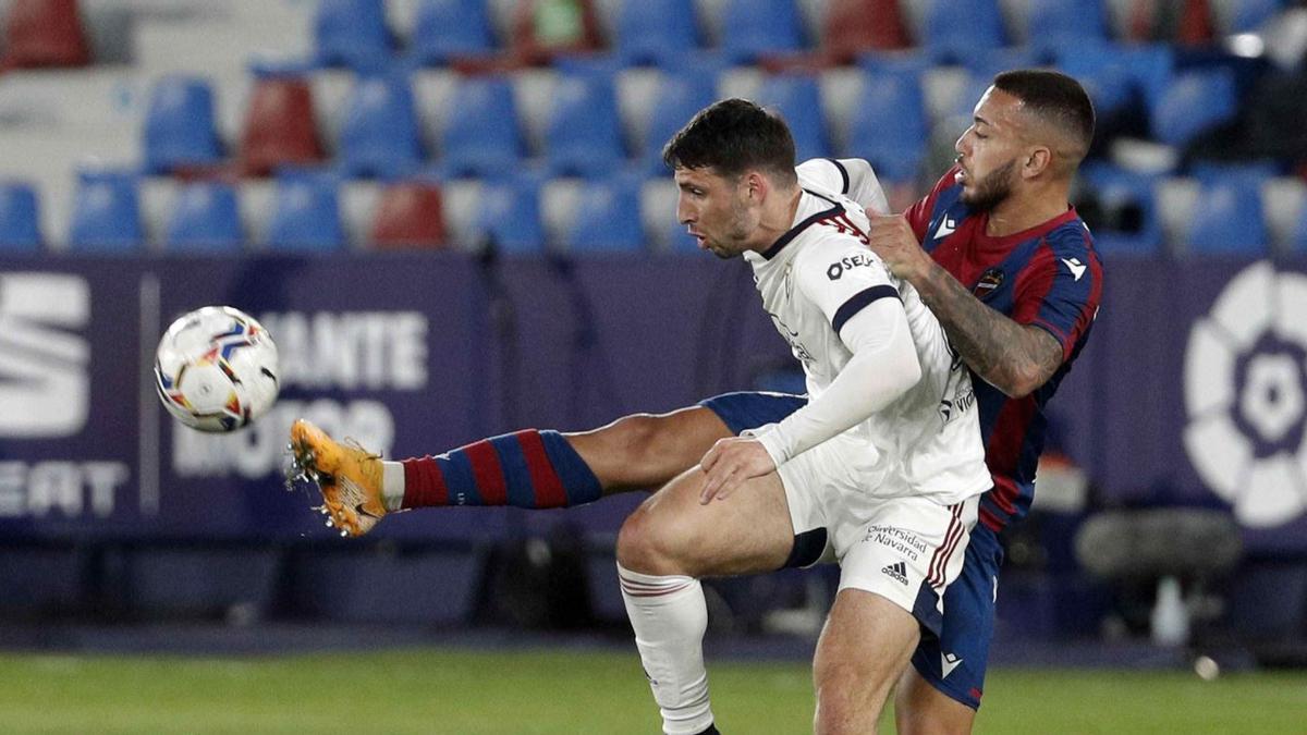 El defensa central, Vezo, disputa el balón frente a un delantero del equipo pamplonés