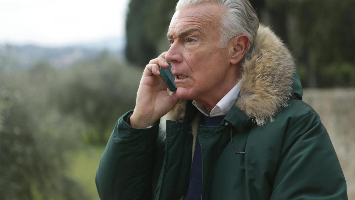 Una persona mayor habla por teléfono móvil: no piques en el timo del botón rojo.