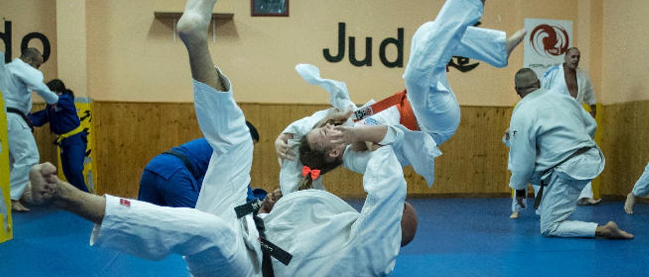 Muestra de un movimiento de judo entre dos generaciones de deportistas.