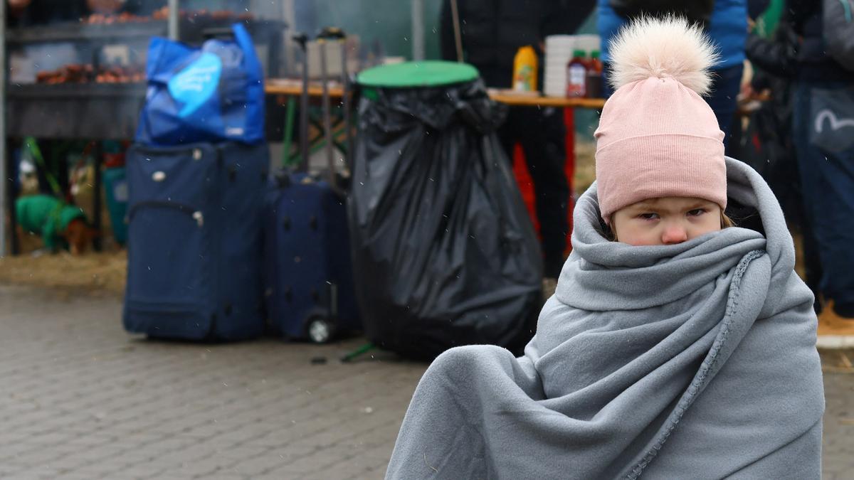Alisa, una niña de 3 años de Kharkiv, se envuelve en una manta después de cruzar la frontera de Ucrania a Polonia junto con su madre, después de huir de la invasión rusa de Ucrania, en el puesto de control fronterizo de Medyka, Polonia, el 9 de marzo de 2022.