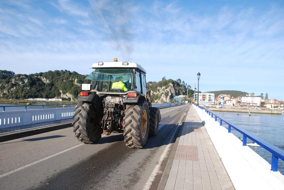 Un tractor circula por el puente de Ribadesella.
