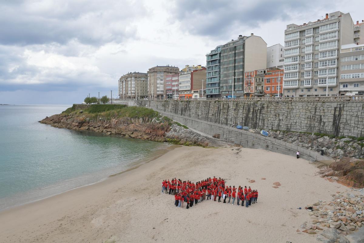 Cruz Roja humana en la playa de Matadero compuesta por delegados de la entidad