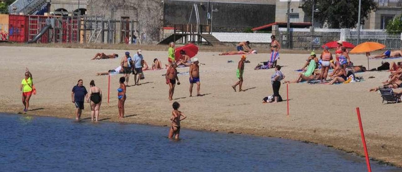 La playa señalizada con estacas y bandera roja ante la aparición de la mancha. // Iñaki Abella