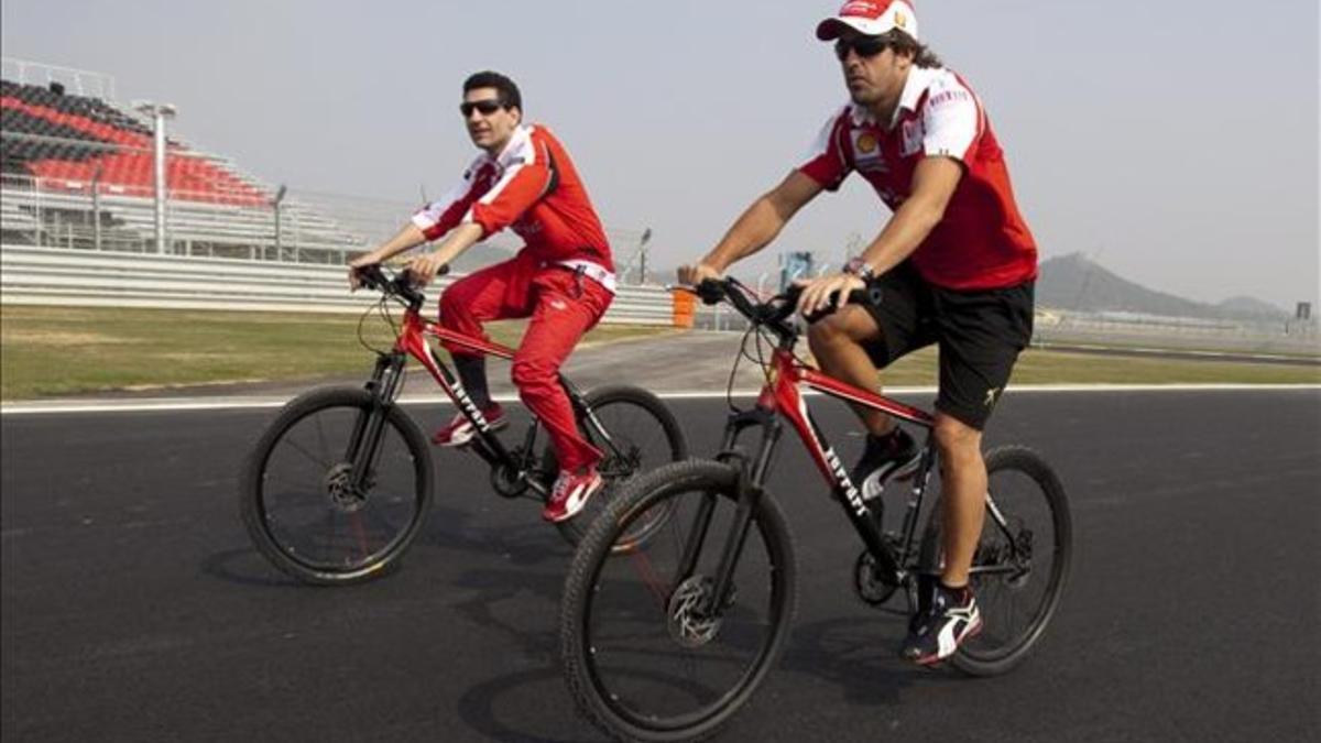 Alonso, con un miembro de su equipo, en un circuito de F-1.