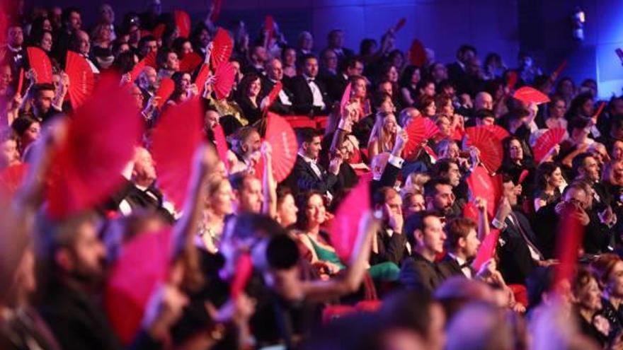 Mujeres muestran los abanicos rojos con el lema «Más mujeres» durante la gala.