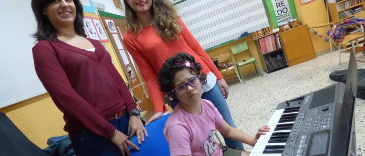 Paula Menéndez y Andrea Calvo, ayer, con Mary Fernández, tocando el teclado durante la clase de musicoterapia.