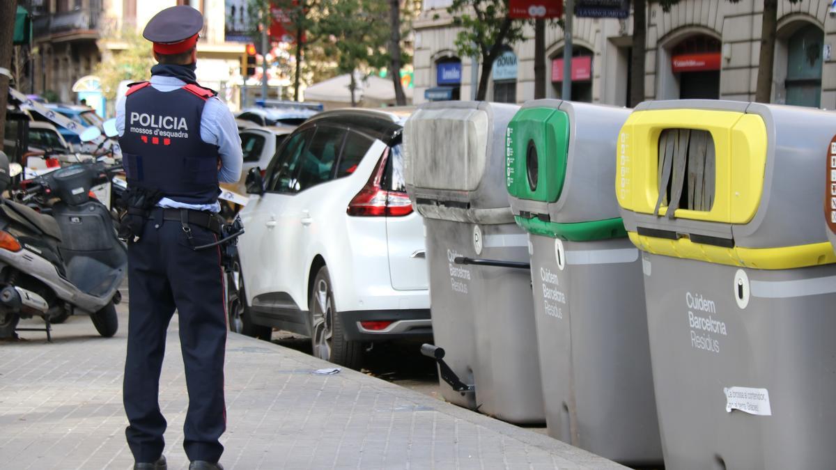 Un agent dels Mossos d'Esquadra al costat del contenidor on s'han localitzat les restes humanes