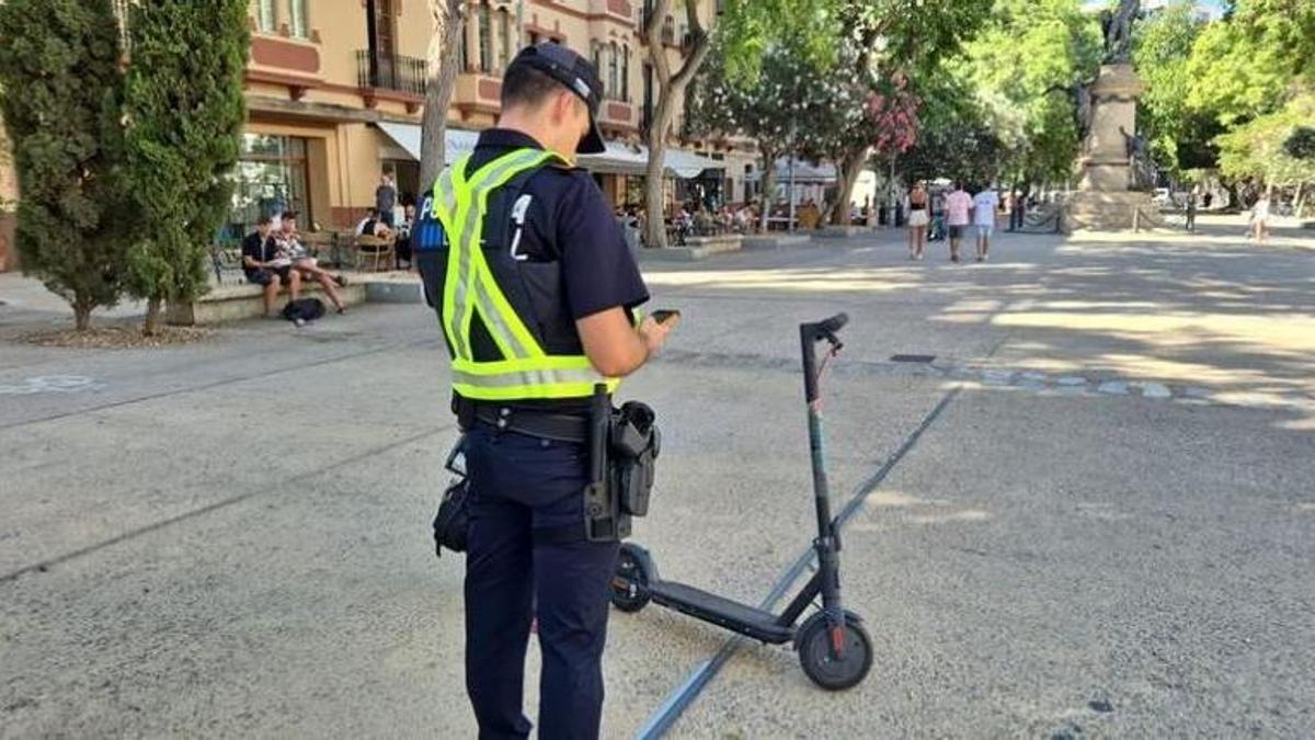 Un agente de la Policía Local toma nota de un patinete eléctrico.