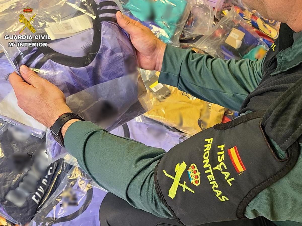 Un guardia civil de Calp con una de las prendas falsas incautadas en Benidorm.