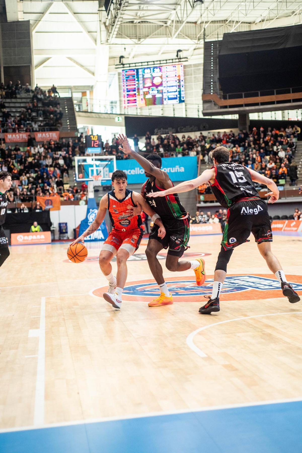 Pacheco, entre dos jugadores del Cantabria en el Coliseum.