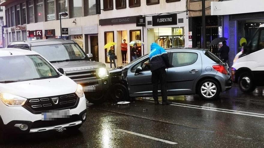 Un policía municipal conversa con el conductor del Peugeot accidentado.