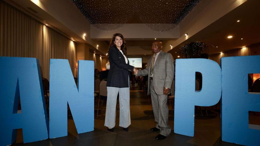 Marta Ibarra García, nueva profesora, y Salvador Beta Bisapa, profesor jubilado, se dan la mano, en el homenaje de Anpe, en Oviedo. | IRMA COLLÍN