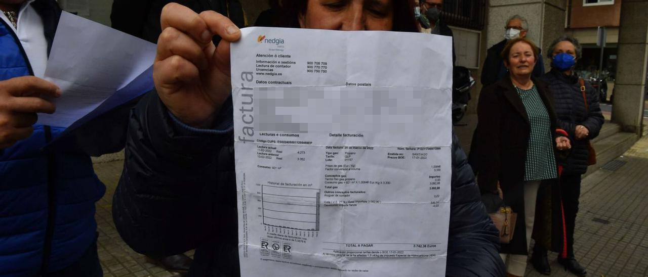 Rita Rodríguez muestra su factura, junto a otros afectados, el sábado pasado, en Acea de Ama