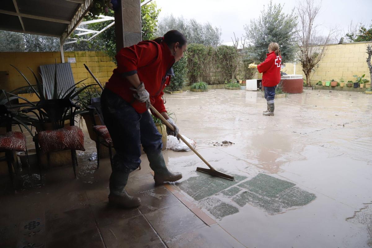 Vecinos de Guadalvalle retiran el lodo de sus casas.