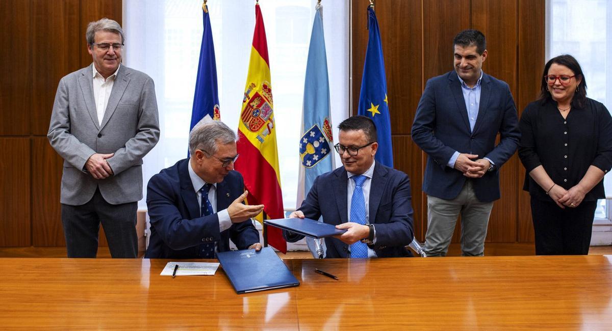 Luis Menor y Xosé González, sentados, tras la firma del protocolo de mejora de plazas de abastos. | IÑAKI OSORIO