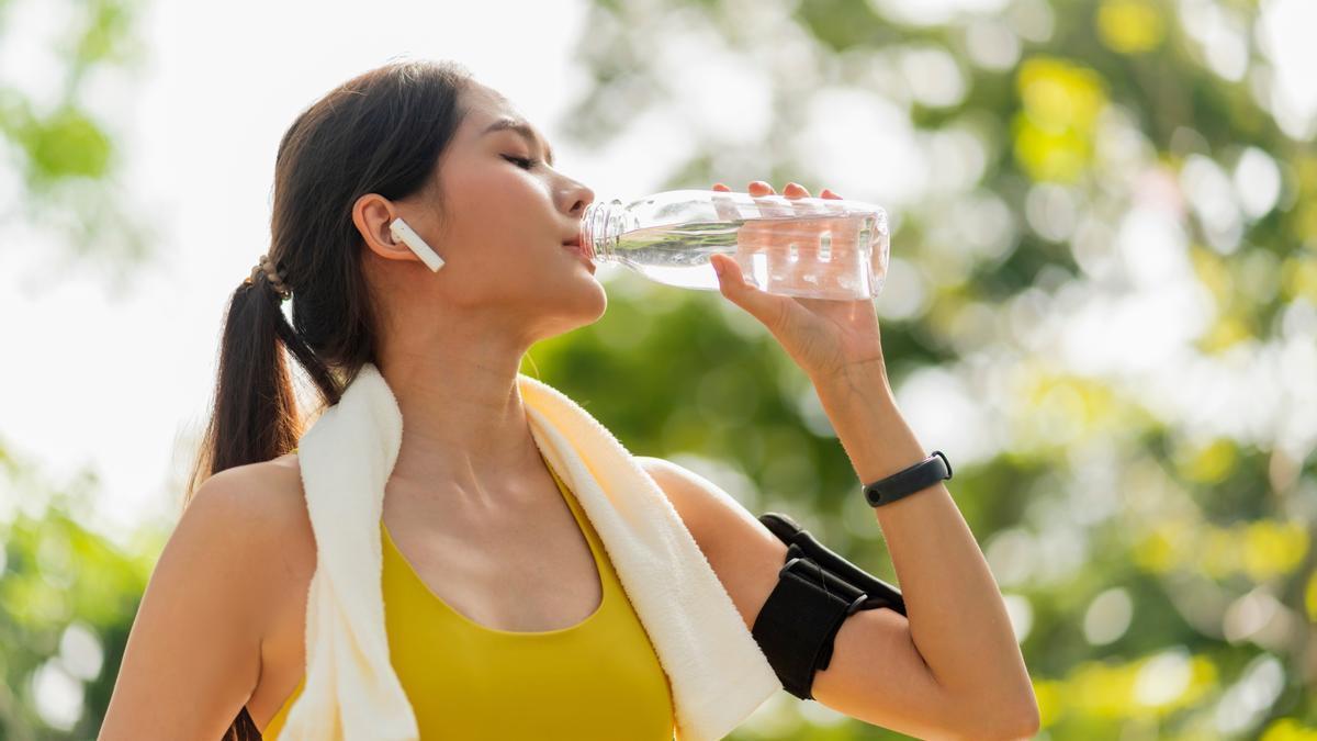 Una mujer bebe agua tras practicar deporte.