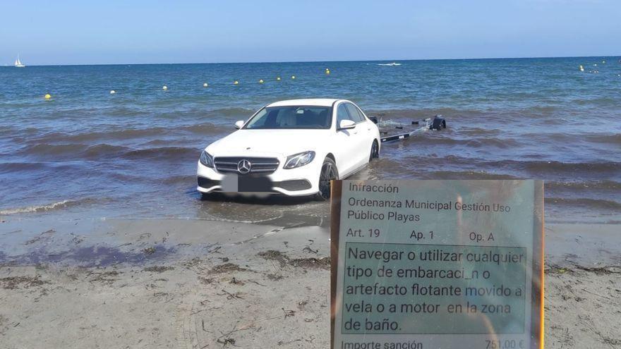 Imagen compartida por la Policía Local de Santa Pola, donde aparece la fotografía del coche aparcado en la orilla de una playa y la notificación de la multa.