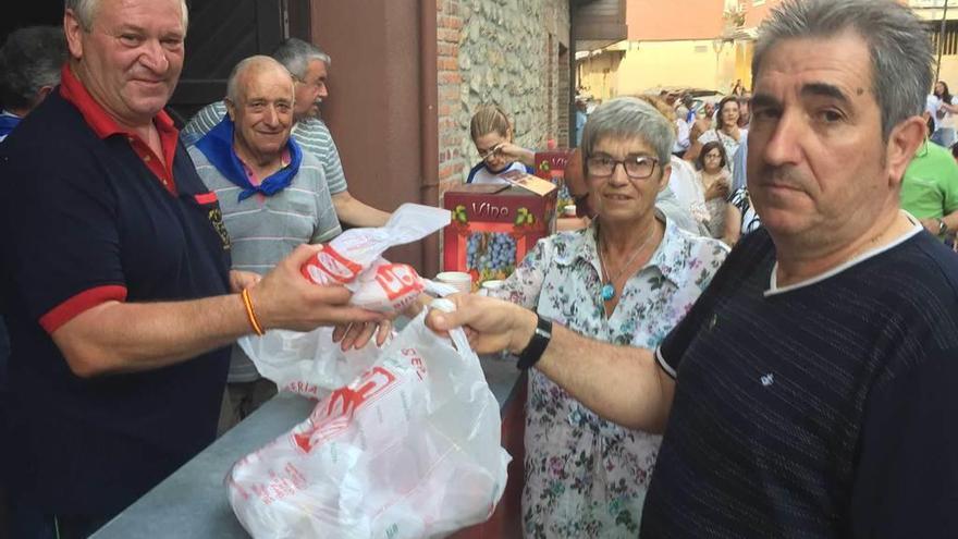 A la izquierda, miembros de la peña &quot;Agua Bendita&quot; animando la fiesta de La Peruyal. Sobre estas líneas, reparto del &quot;bollín&quot;.