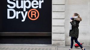 FILE PHOTO: A woman walks past a window display at a Superdry store in London, Britain, March 1, 2019. REUTERS/Toby Melville/File Photo