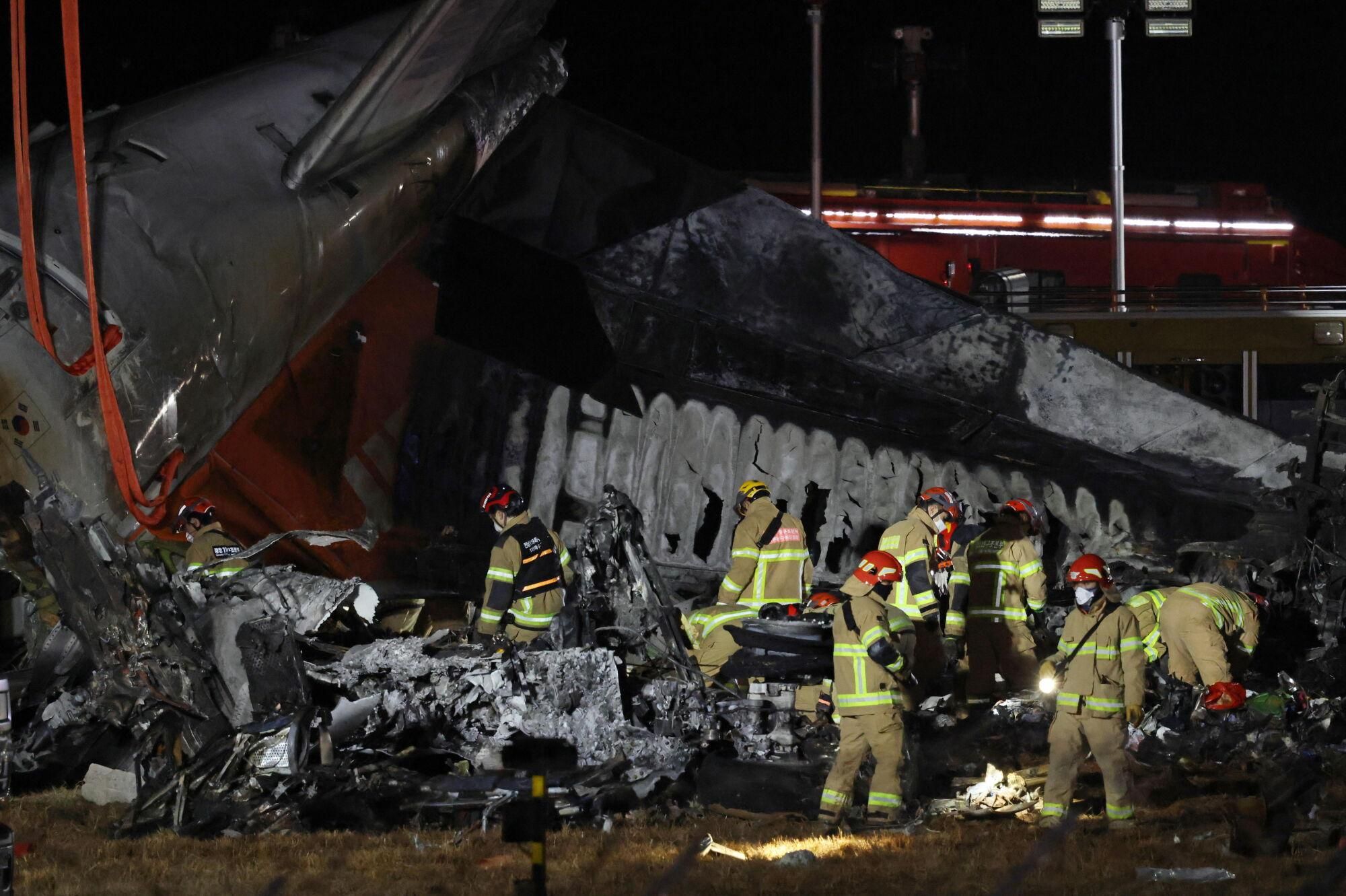 Muan (South Korea), 29/12/2024.- Firefighters work near the wreckage of a Jeju Air aircraft at Muan International Airport in Muan, South Jeolla Province, South Korea, 29 December 2024. According to the South Korea National Fire Agency (NFA), a passenger jet carrying 181 people erupted in flames after going off the runway at an airport in South Korea's southwestern county of Muan on 29 December, leaving at least 176 people dead and 3 missing, as two crew members survived. (Corea del Sur) EFE/EPA/HAN MYUNG-GU