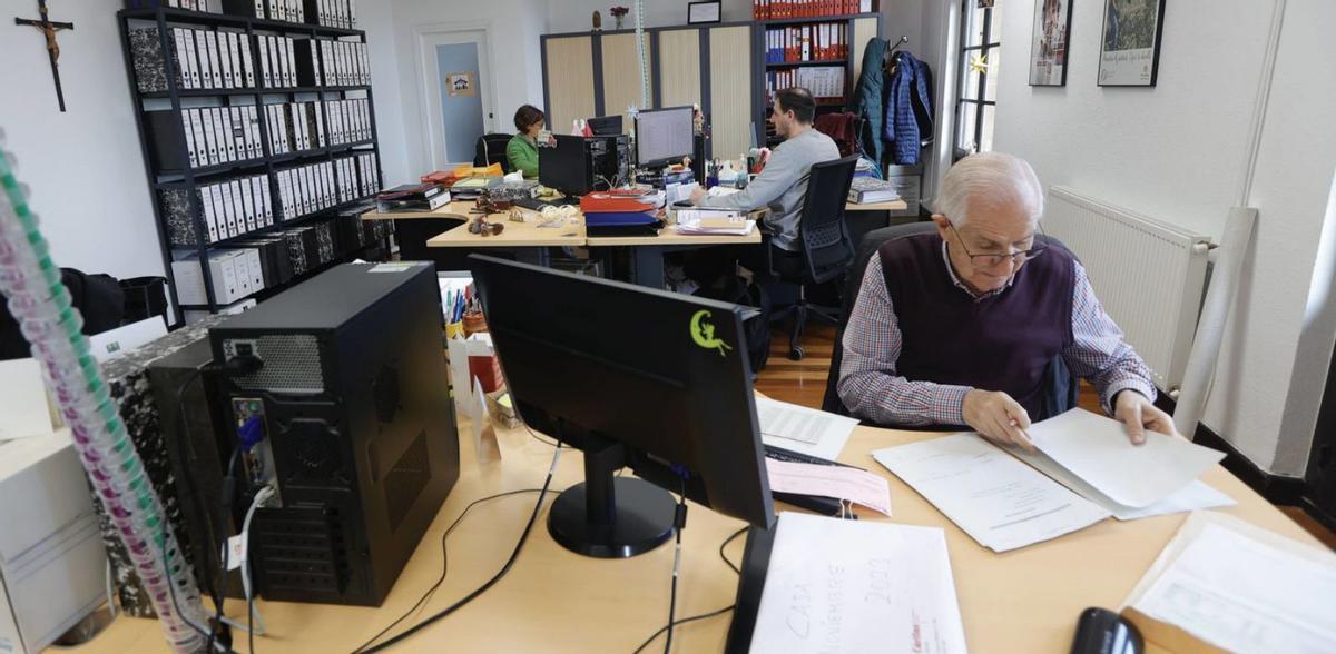 Arriba, una de las oficinas donde se realizan labores administrativas; sobre estas líneas, varias trabajadoras de Cáritas Diocesana, en una sala de reuniones de la nueva sede de San Isidoro. | Miki López