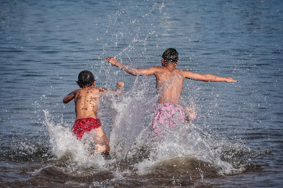 Unos niños se refrescan en la playa de Las Teresitas.