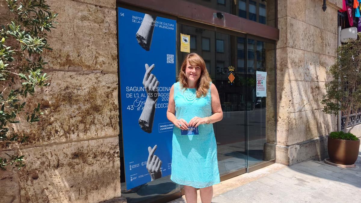 La concejala de Compromís, M.Picó con la programación en la mano y junto al cartel del festival
