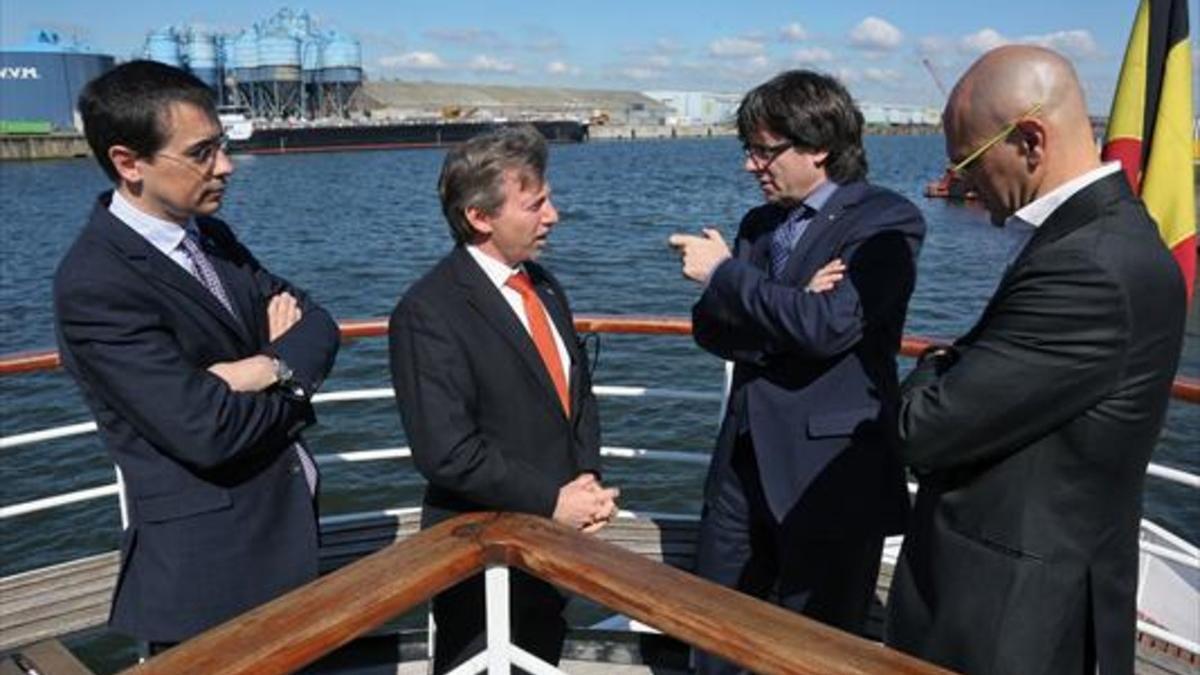 Altafaj (izquierda), Puigdemont y Romeva (derecha), con una autoridad local en su visita al puerto de Gante, ayer.