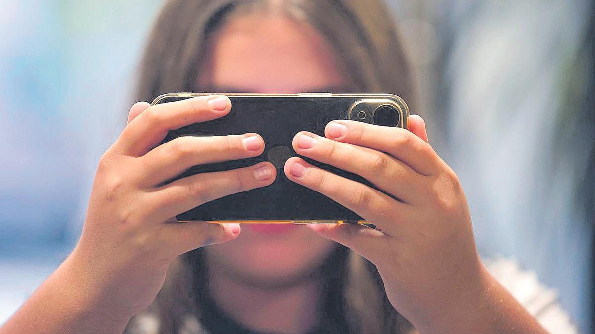 Una joven sostiene su teléfono móvil, en una imagen de archivo.