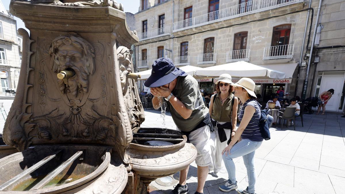Turistas se refrescan de las altas temperaturas en una fuente de Pontevedra.