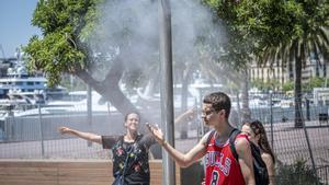 Varias personas se refrescan en una fuente. EPC