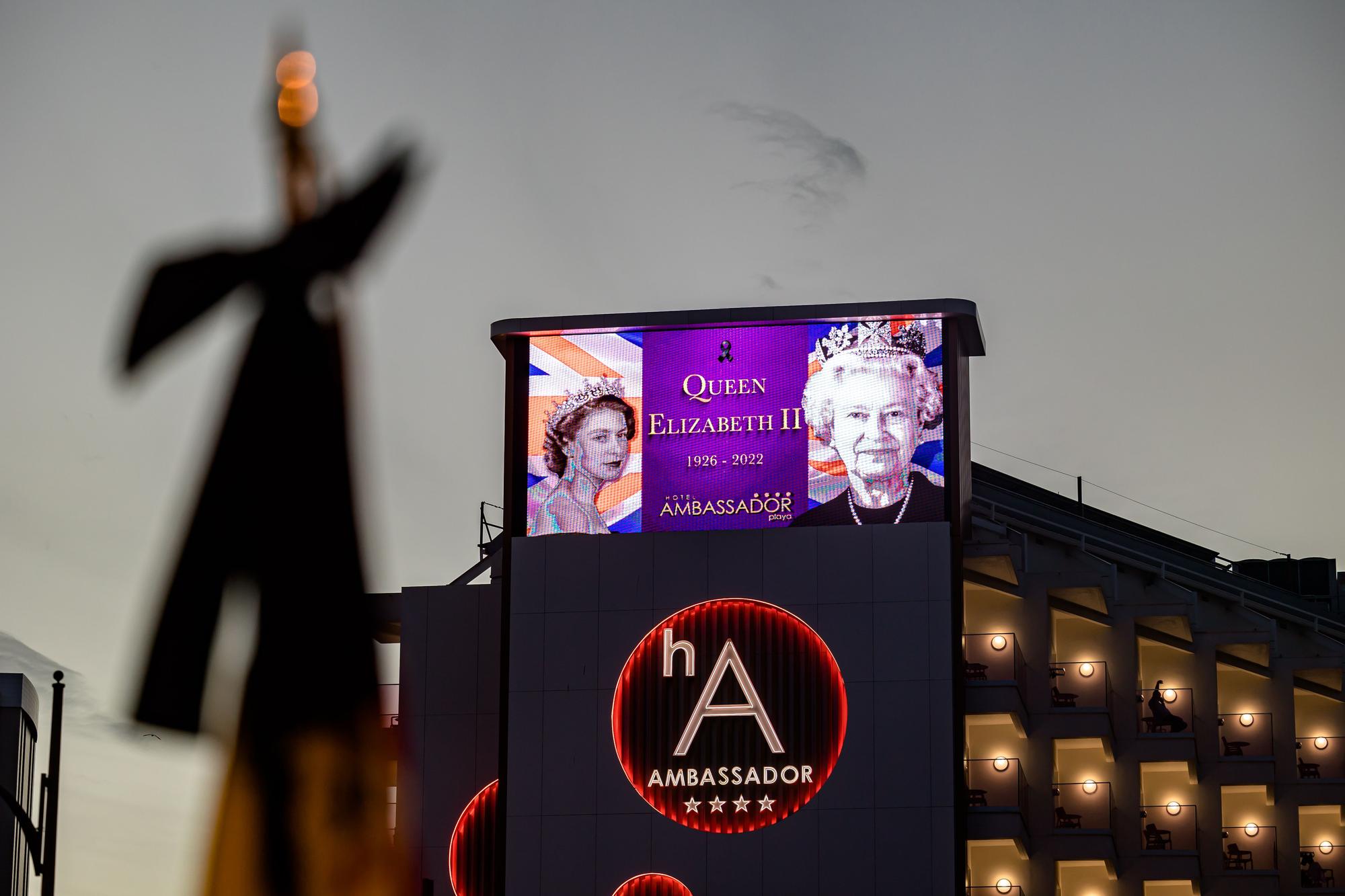 Británicos residentes y turistas de Benidorm rinden un sentido homenaje a Elizabeth II en el espacio habilitado por el Ayuntamiento en la zona inglesa de la ciudad.