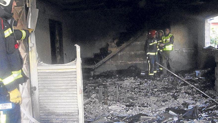 Feuerwehr und Polizei inspizierten das ausgebrannte Chalét nach dem Feuer.