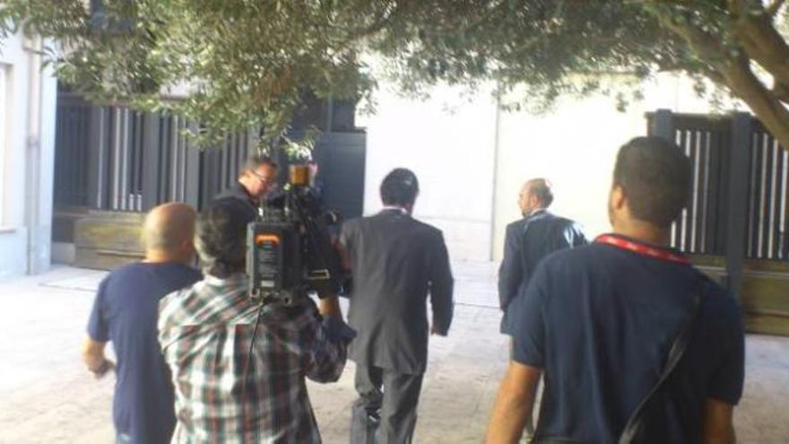 Los periodistas siguieron ayer hasta los exteriores de las Corts al vicepresidente. A la derecha, el informador de Canal 9, con el jefe de prensa.