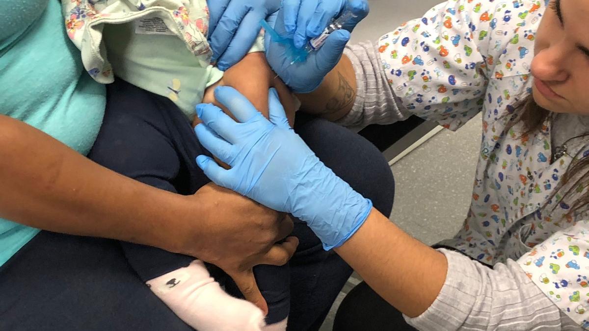 Una enfermera vacuna a un bebé contra la gripe