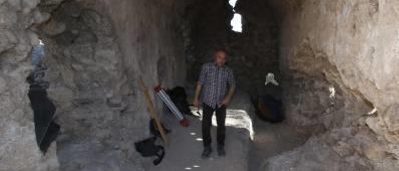 El arqueólogo Miquel Gómez muestra la muralla encontrada en el castillo de Corbera.
