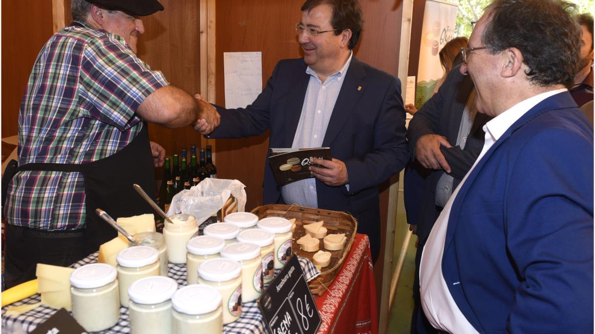 El presidente de la Junta saluda a los queseros de la 6 Feria Europea del Queso en una pasada edición, junto al alcalde de Casar de Cáceres, Rafael Pacheco.