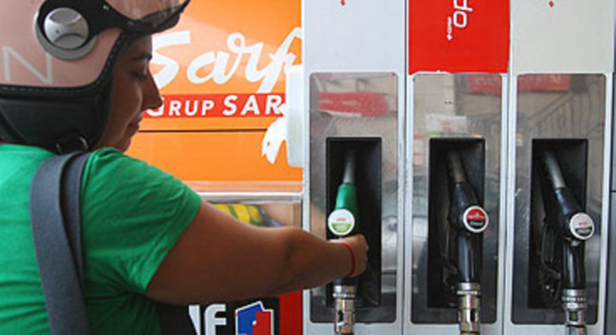 Una dona es disposa a posar gasolina a la seva moto.